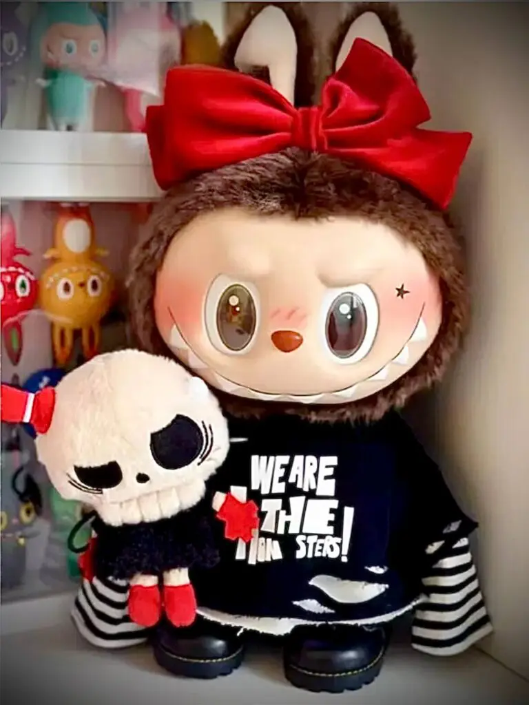 Large Labubu plush doll called Catch Me If You Like Me of Labubu and her boyfriend Tycoco on a white shelf with Labubu figurines behind them