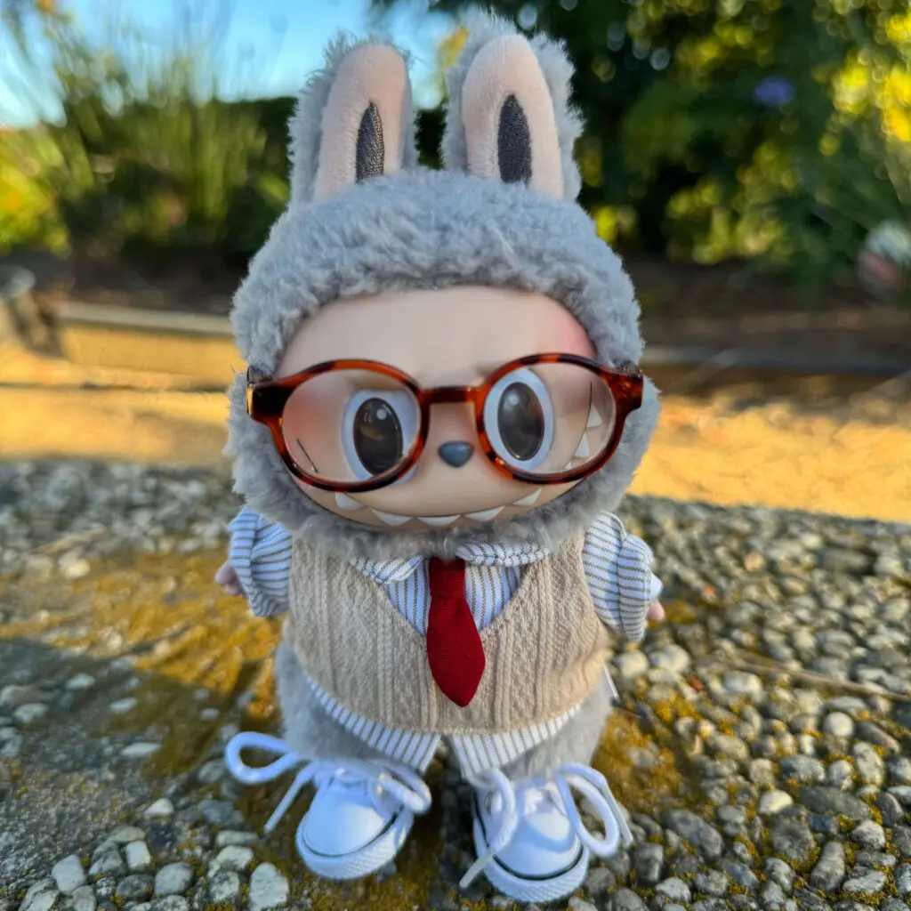 labubu sesame bean dressed in labubu clothes w glasses and sweater outdoors