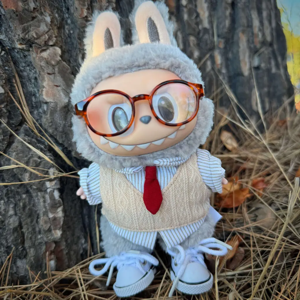 Labubu Sesame Bean in an outdoor setting wearing a vest and tie, glasses, and white sneakers