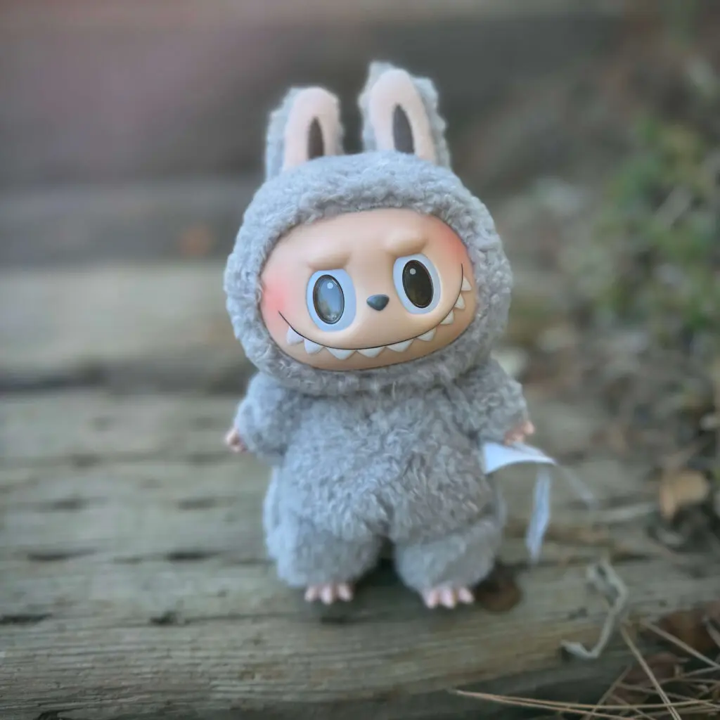 labubu doll named sesame bean from exciting macaron series standing outside on wooden stairs