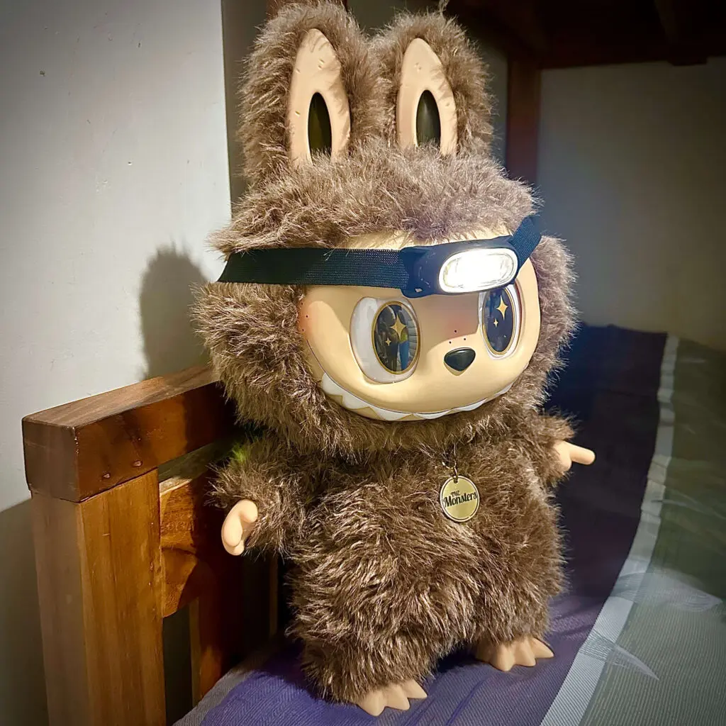 Labubu Zimomo with flashlight in living room