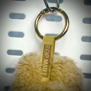 Back view of Labubu Toffee pendant with embroidered branding