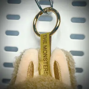 Close-up of Labubu Toffee pendant with embroidered lanyard and gold hardware