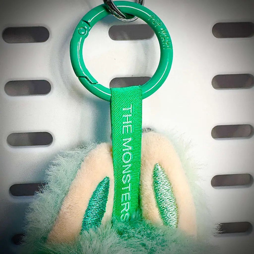 Closeup of lanyard of Labubu doll called Serenity showing Monsters engraving