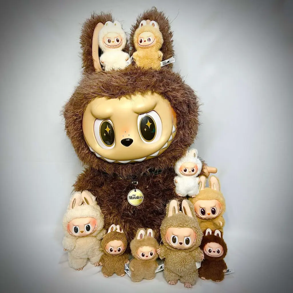Group photo of large Labubu plush doll Zimomo with smaller brown Labubu keychain dolls