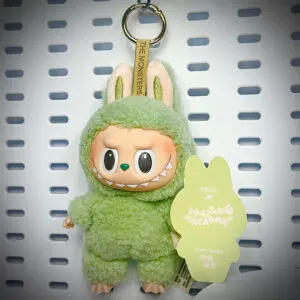 Labubu Green Grape doll from Exciting Macaron series hanging on a white pegboard with pop card