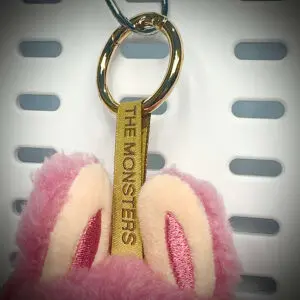 Close-up of Labubu Lychee Berry pendant with embroidered lanyard and gold hardware