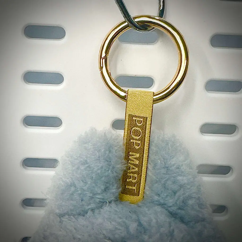 Labubu doll Sea Salt Coconut close-up: The Pop Mart engraving on lanyard (Exciting Macaron series)