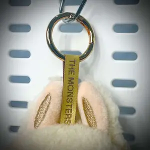 Close-up of Labubu Soymilk pendant with embroidered lanyard and gold hardware