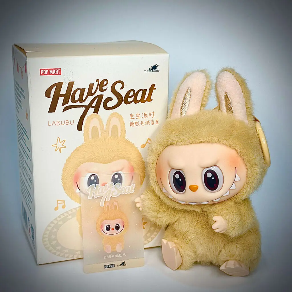 Labubu doll Baba from Have a Seat series next to box and Pop card