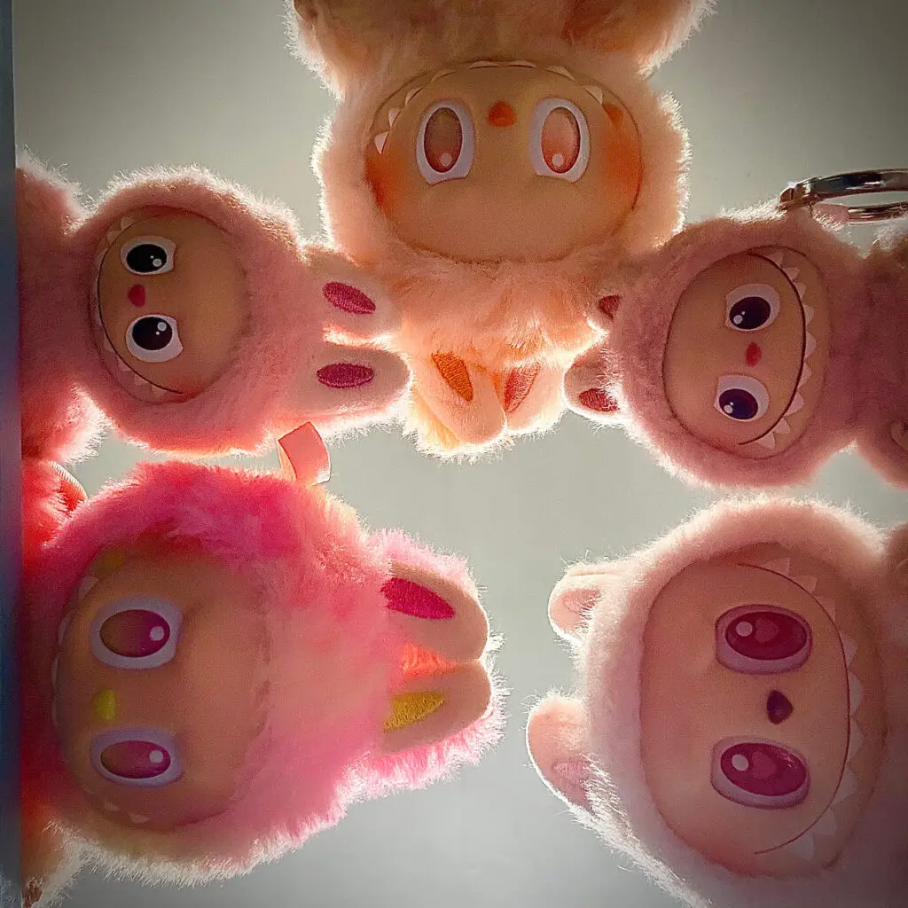 5 pink Labubu dolls peering down at the camera
