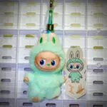 Mini Labubu Pin For Love Imagination I hanging on a white pegboard with sticker name