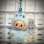 Mini Labubu Pin For Love Dollar D hanging on a white pegboard with sticker name