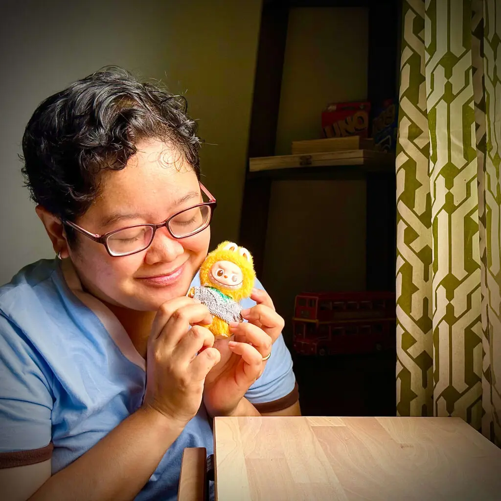 Woman holding Mini Labubu Pin For Love Yes Y dolla