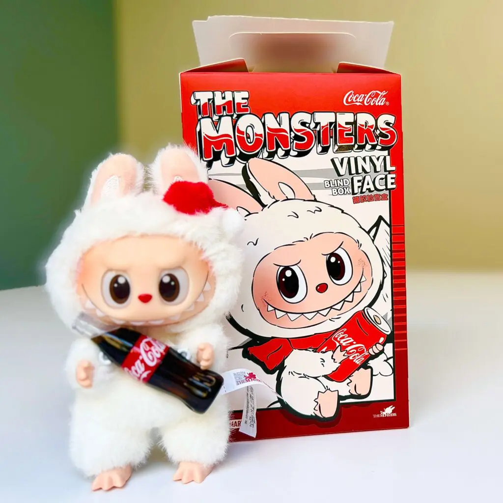 Coca-Cola Labubu doll Surprise Shake next to an opened blind box