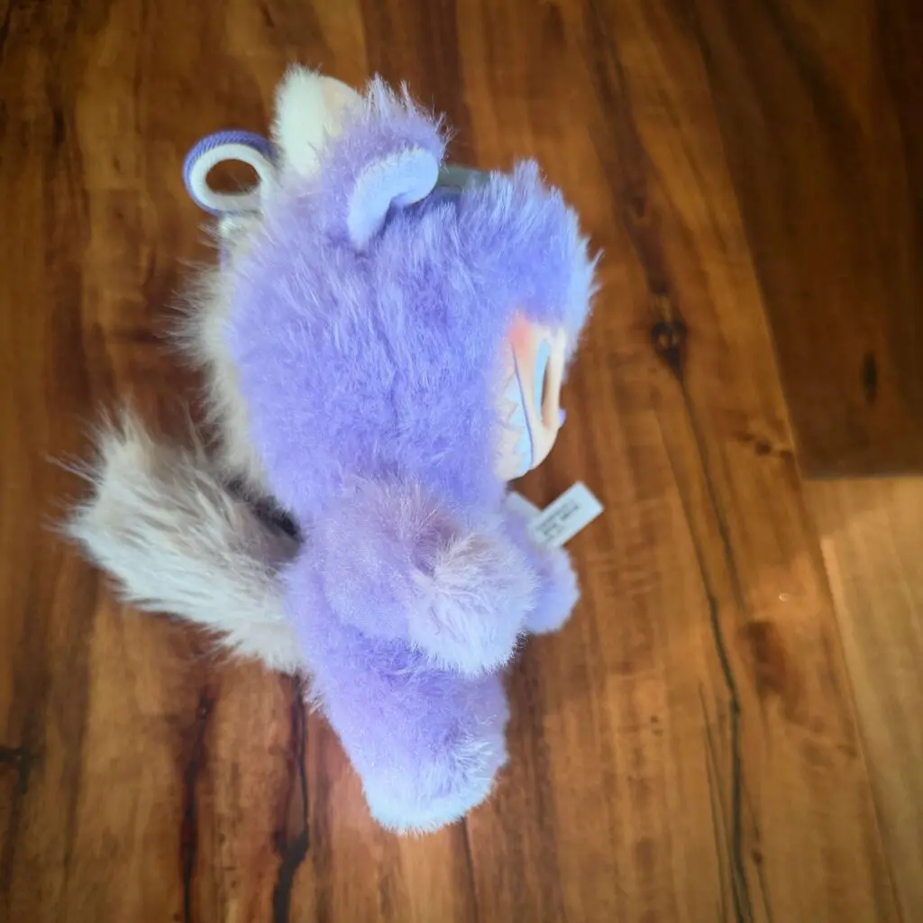 Side view of the Pop Mart Labubu Happy Family plush doll from the 2026 Have a Good Run CNY series showing grey tail