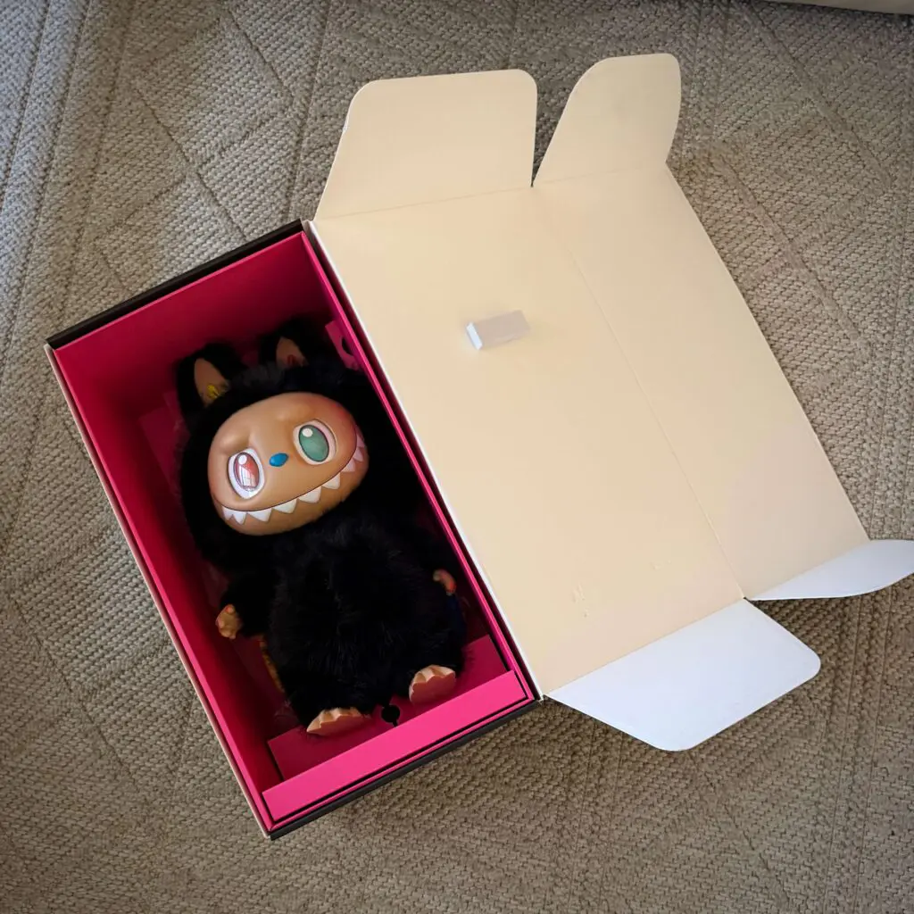 labubu zimomo 10th anniversary doll lying inside opened box and staring up