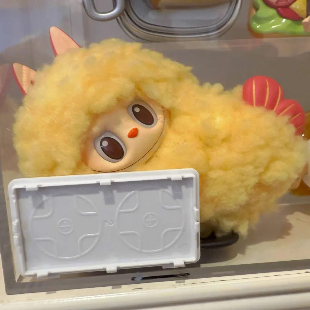 Labubu Wacky Mart Series Shrimp Tempura keychain earphone case in display stand at Pop Mart store
