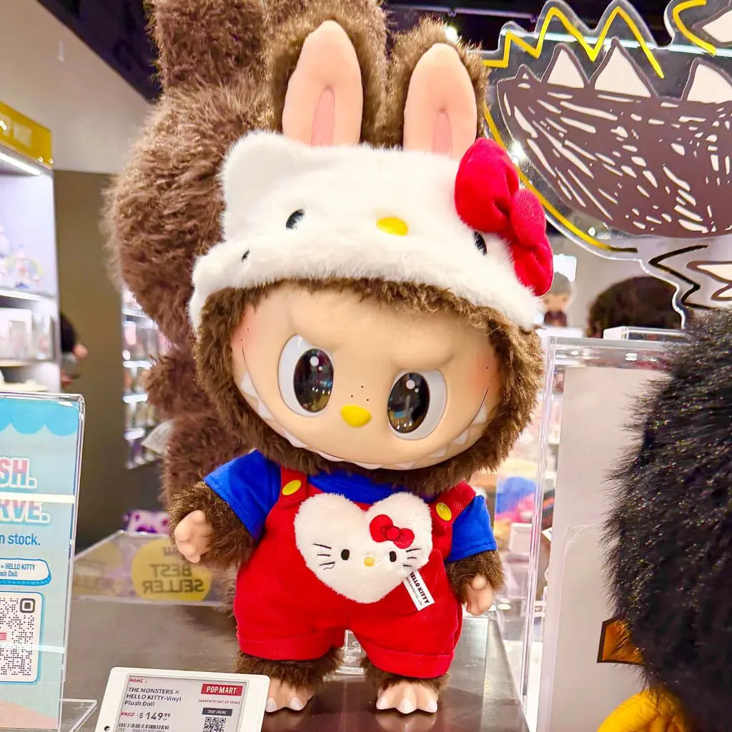 Labubu Hello Kitty plush doll on a store display inside a PopMart store