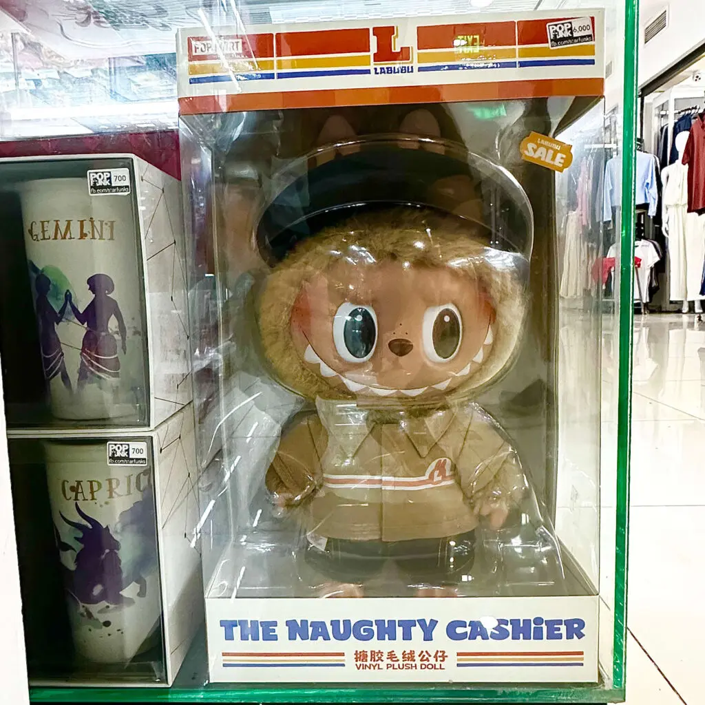 Labubu The Naughty Cashier plush doll on a store display inside the box