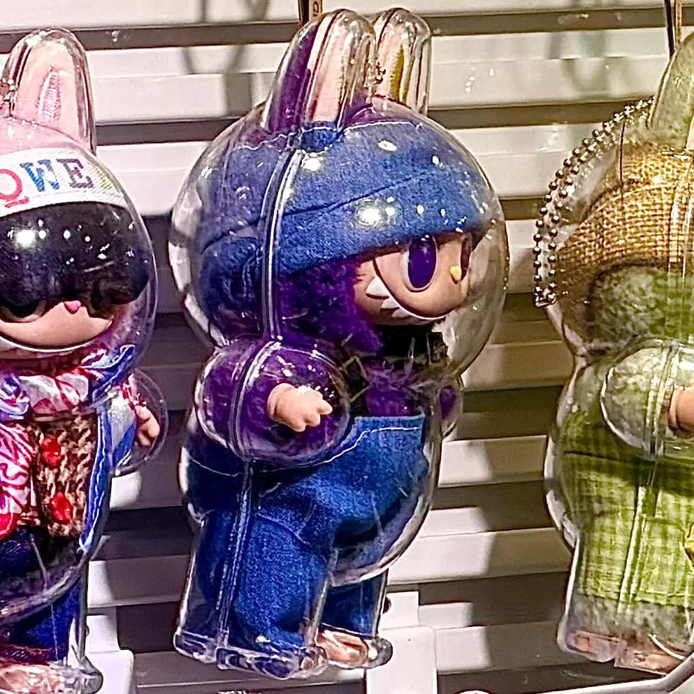 lafufu purple keychain doll wearing denim clothes and inside an acrylic protective case