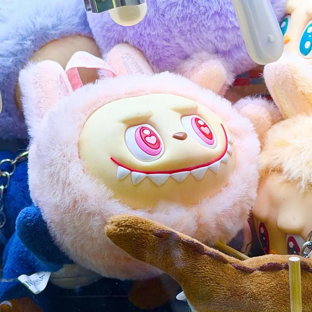 fake labubu, lafufu pink head inside a claw machine