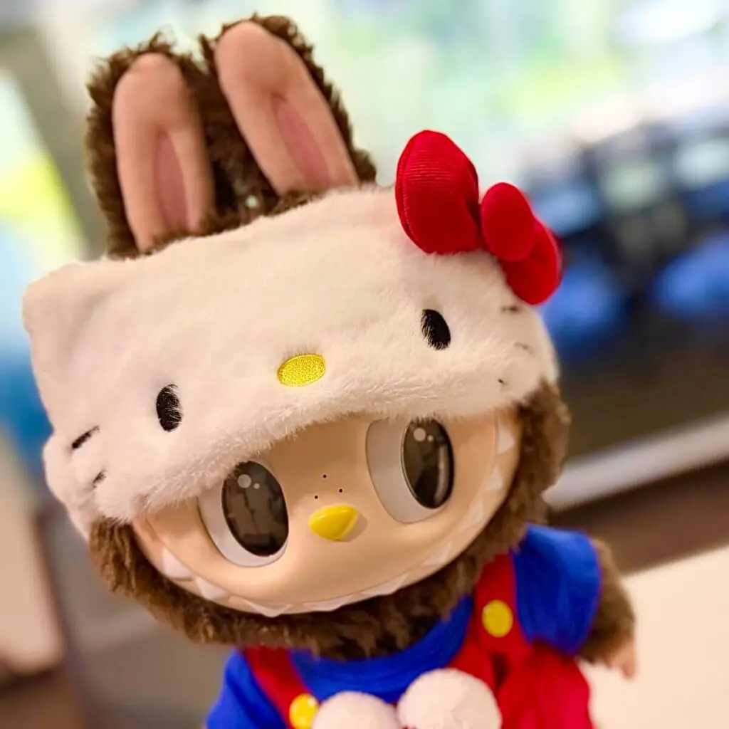 Close up of Labubu x Hello Kitty plush doll on a blurred background