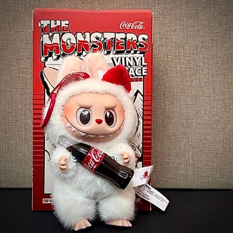 labubu coca cola doll standing in front of blind box